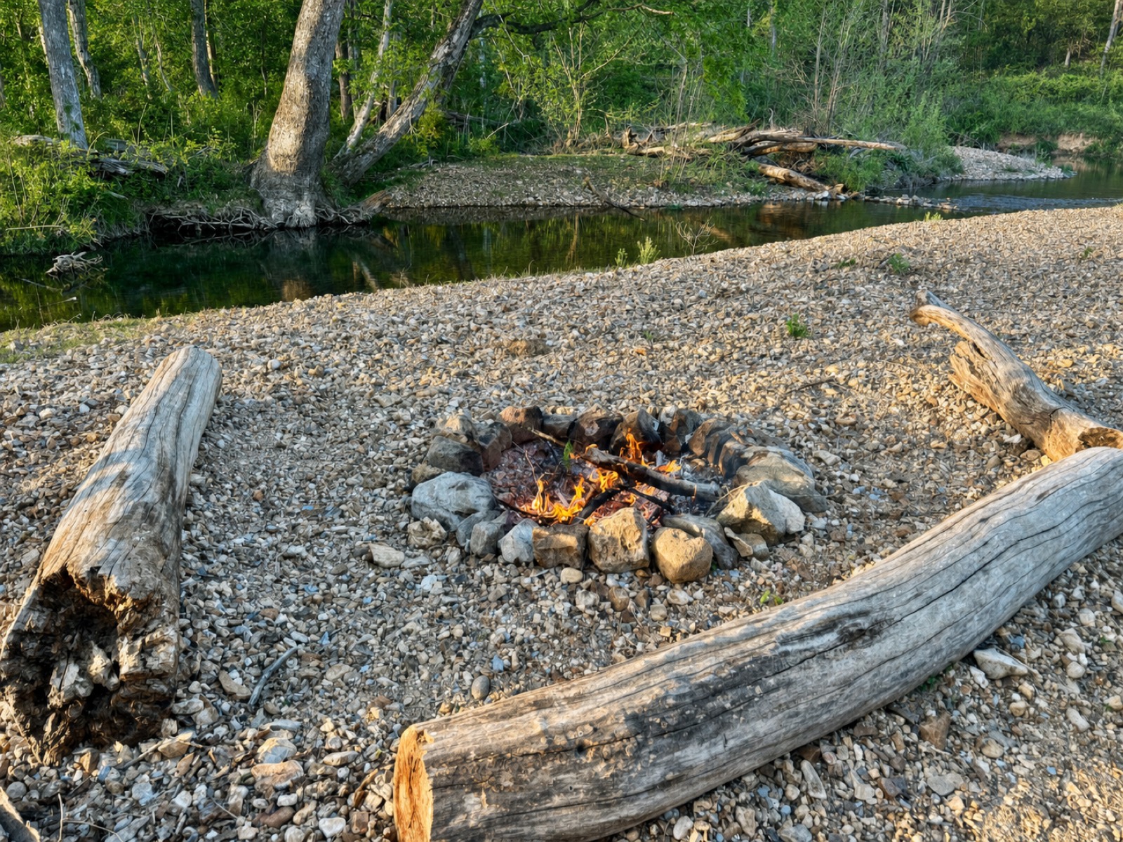 Creekside firepit ringed with log benches